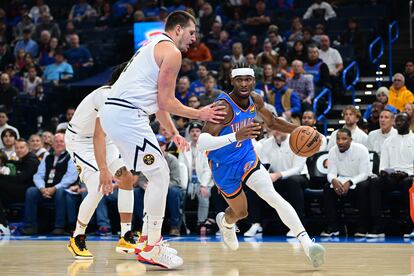 Shai Gilgeous-Alexander vota el balón ante Nikola Jokić, en una imagen de archivo.