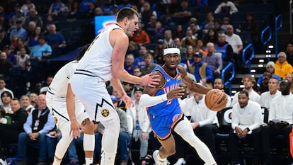Shai Gilgeous-Alexander vota el balón ante Nikola Jokić, en una imagen de archivo.