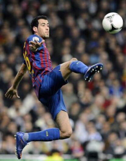 Busquets salta para controlar el balón.