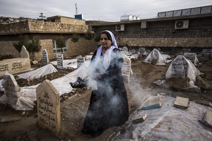 Una mujer bendice las tumbas de los yazidíes fallecidos en el cementerio de la ciudad de Lalish.