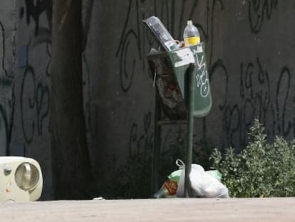 Papeleras rebosantes y desperdicios en el suelo de una calle de Madrid el pasado s&aacute;bado. 