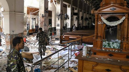 EDITORS NOTE: Graphic content / Sri Lankan security personnel walk past dead bodies covered with blankets amid blast debris at St. Anthony's Shrine following an explosion in the church in Kochchikade in Colombo on April 21, 2019. - A string of blasts ripped through high-end hotels and churches holding Easter services in Sri Lanka on April 21, killing at least 156 people, including 35 foreigners. (Photo by ISHARA Séc. KODIKARA / AFP)