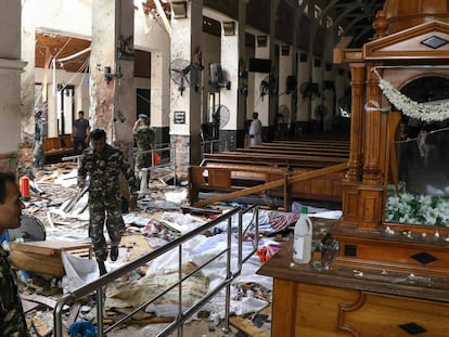 EDITORS NOTE: Graphic content / Sri Lankan security personnel walk past dead bodies covered with blankets amid blast debris at St. Anthony's Shrine following an explosion in the church in Kochchikade in Colombo on April 21, 2019. - A string of blasts ripped through high-end hotels and churches holding Easter services in Sri Lanka on April 21, killing at least 156 people, including 35 foreigners. (Photo by ISHARA Séc. KODIKARA / AFP)