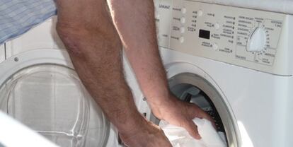 Un hombre introduce ropa en una lavadora dom&eacute;stica. EFE/Archivo