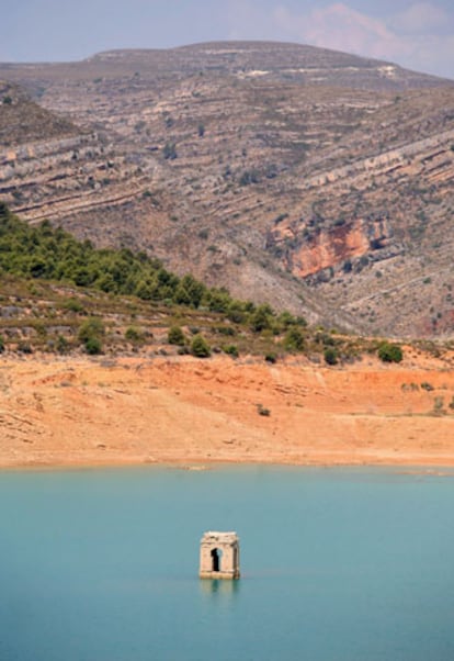 El campanario de una iglesia se asoma sobre el nivel del agua en el embalse de Tous, cerca de Valencia. El nivel del agua de los embalses ha disminuido de tal modo que en algunos lugares permite ver los restos de los pueblos anegados.