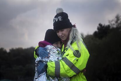 <span style="font-family: arial,helvetica,sans-serif; font-size: 8pt;">Una voluntaria abraza a un niño recién sacado del mar en la playa de Lesbos, Grecia, el 18 de diciembre. (AP Photo/Santi Palacios)</span>