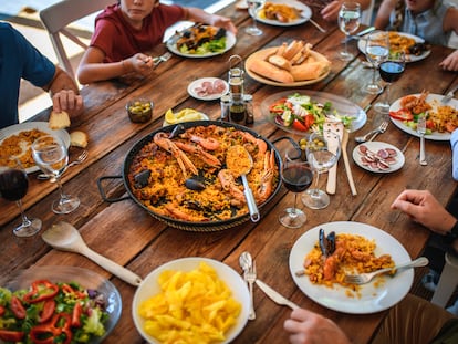 Comida alrededor de una paella.