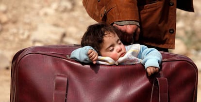 Una niño duerme dentro de una maleta en Beit Sawa (Siria).