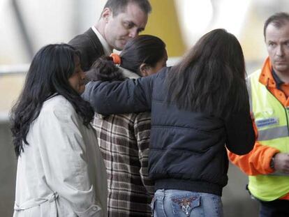 Allegados de las víctimas se abrazan en el aparcamiento de la terminal 4 de Barajas.
