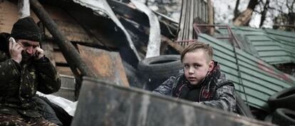 Un niño se calienta junto al fuego en una barricada en el centro de Kiev.
