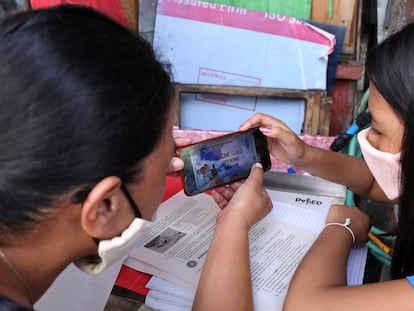 Christine Mae Escobido (derecha), de 11 años, y su madre Warlyn Langit estudian Geografía con la ayuda de un móvil en el barrio de Santa Ana, en Manila. 