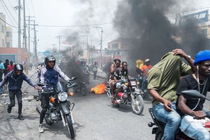 Varias personas huyen durante una protesta de policías en Puerto Príncipe (Haiti). El miedo ganó las calles de la ciudad cuando cientos de policías se manifestaron encapuchados y armados para protestar contra el Gobierno y exigir la liberación de un camarada detenido por un asunto de tráfico de drogas.