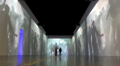 Unos espectadores observan la película proyectada en la pared que forma parte de la exposición 'The Unknown', presentada por el fotógrafo alemán Peter Lindbergh en una galería en Pekín el 28 de abril de 2011.
