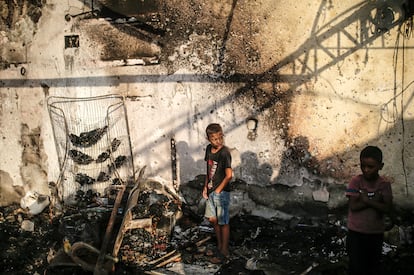 Dos niños pasean entre los escombros causados por el bombardeo israelí en un campamento de refugiados cerca del hospital Al-Aqsa, este lunes.