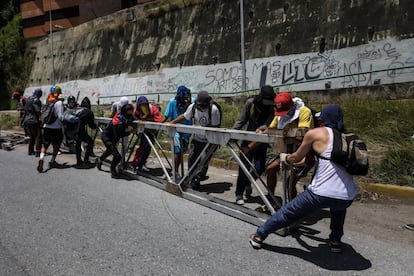 Un grupo de opositores trata de formar una barricada durante la manifestación contra la Asamblea Nacional Constituyente.