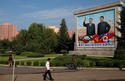 Residentes passam próximo a uma pintura dos últimos líderes norte-coreanos, Kim Il Sung e Kim Jong Il, em Pyongyang.