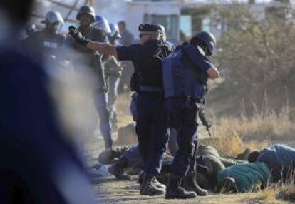 Unos policías inspeccionan los cuerpos sin vida de unos mineros abatidos en los tiroteos acontecidos cerca de una planta minera en Rustenburgo (Sudáfrica) hoy.