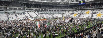 Los aficionados del Juventus saltan al cesped del estadio del equipo de Turín para celebrar el título de liga.