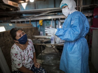 Mulher chora depois de coleta de sangue durante um teste de coronavírus em Lima, Peru.