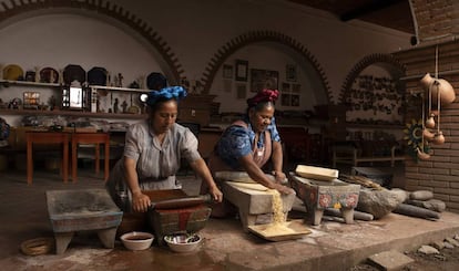 Rosario y Abigail Mendoza (derecha) muelen chile y maíz en el restaurante Tlamanalli, Oxaca.