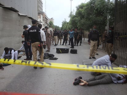 La policía examina los cuerpos de los terroristas que este lunes han atacado la Bolsa de Karachi (Pakistán).