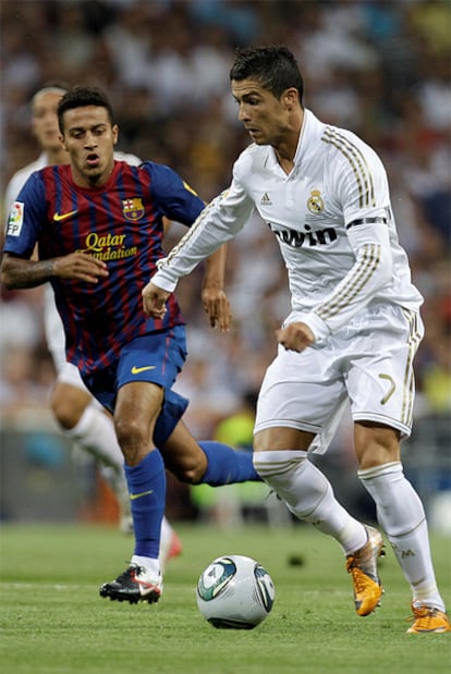 El jugador portugués conduce el balón ante la atenta mirada de Thiago.