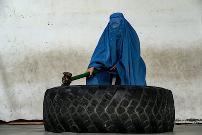 An Afghan woman who practices jiujitsu, a Japanese martial art, poses with a sledgehammer she uses for strength exercises in Kabul, Afghanistan. One female athlete interviewed by AP recalls she was competing in a local women's tournament when the Taliban arrived in Kabul. Word spread through the crowd that the Taliban were advancing on the outskirts of the city. All the women and girls fled the pavilion. It was the last competition she participated in.