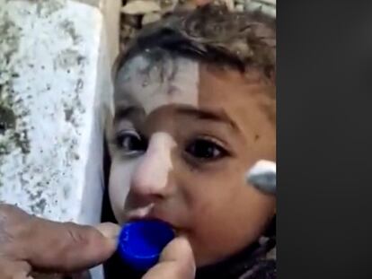 Muhammed ahmed bebe agua de un tapón entre los escombros en Turquía