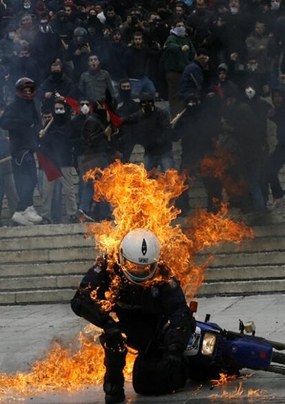 Un policía intenta huir de las llamas tras recibir el impacto de un cóctel molotov en Atenas