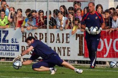 Casillas detiene un balón, en el entrenamiento de la selección, mientras Reina espera su turno.