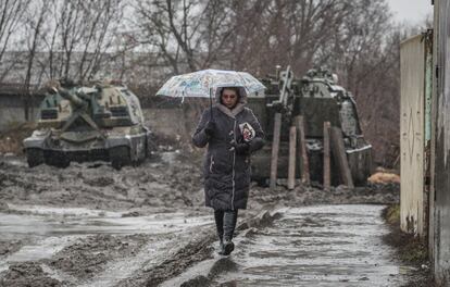 Una mujer camina frente a vehículos blindados rusos en la estación de tren en la región de Rostov (Rusia).