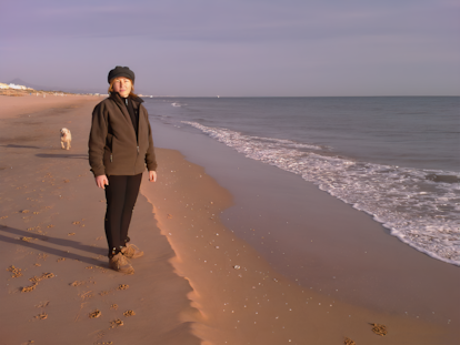 Teresa Vicetto, editora de 'El Cárabo', en la playa con su perra Canela.