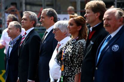 Bernie Ecclestone (c) y Miguel &Aacute;ngel Mancera, jefe de Gobierno de la ciudad de M&eacute;xico (2i), escuchan el himno nacional mexicano previo al banderazo de salida del Gran Premio.