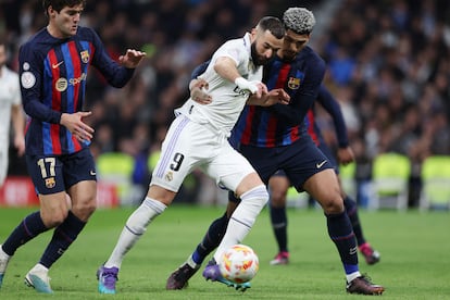 Benzema controla el balón ante la presión de Marcos Alonso y Araujo.