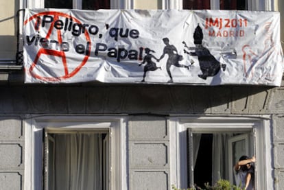 Carteles en contra de la visita del Papa en un balcón del barrio de Huertas.
