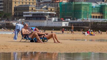 Varias personas disfrutan el lunes de la playa en San Sebastián.