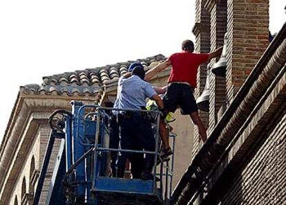 Agentes municipales desalojan a uno de los <i>okupas</i> de la antigua iglesia de Jesús y María.