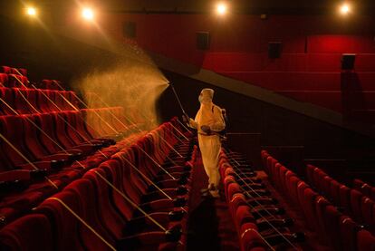 Un operario desinfecta una sala de cine de Basra (sur de Irak), tras la relajación de las normas impuestas para parar el avance de la covid-19 por parte de las autoridades.