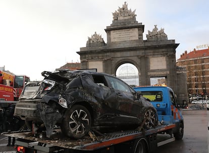 Una grúa transporta un coche siniestrado en la Puerta de Toledo de Madrid.