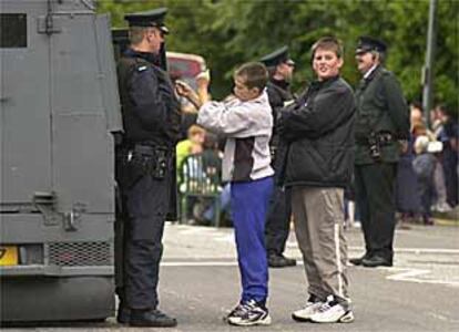 Niños protestantes bromean con la policía británica en Belfast.