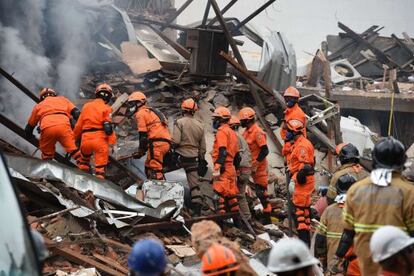 Bomberos buscan víctimas tras una explosión.