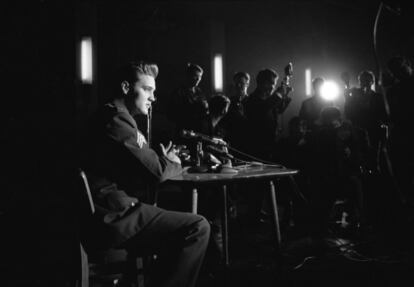Elvis Presley, cuando era sargento del Ejército de los Estados Unidos, en una rueda de prensa sobre su gira en se sienta en una mesa durante la rueda de prensa en su gira de trabajo en Alemania, en 1960.