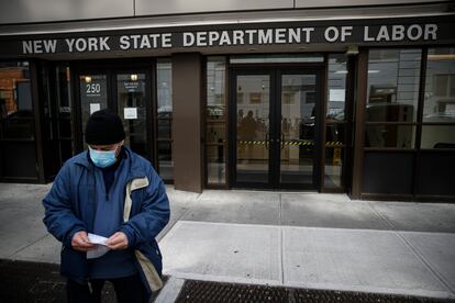 Homem de máscara contra o coronavírus na frente de agência do Departamento do Trabalho em Nova York.