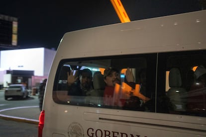 Migrantes que fueron deportados de Estados Unidos a México saludan mientras son transportados a un refugio en Tijuana, México, la noche de este martes.