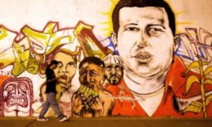 Un hombre pasea por delante de un mural de Hugo Chávez.