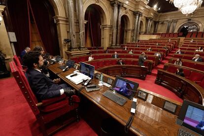 El presidente del Parlament, Roger Torrent, escucha la intervención del presidente de la Generalitat, Quim Torra, durante el pleno del Parlament que este viernes celebra el debate final de los presupuestos de la Generalitat para este año..