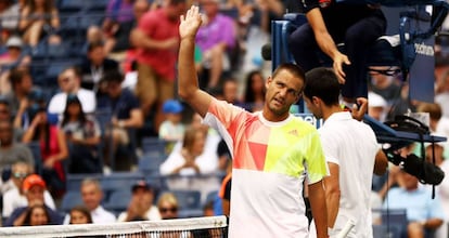 Youzhny se disculpa ante el público de Nueva York, con Djokovic en un segundo plano.