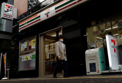 Un peatón camina frente a una tienda de 7-Eleven en Tokio.