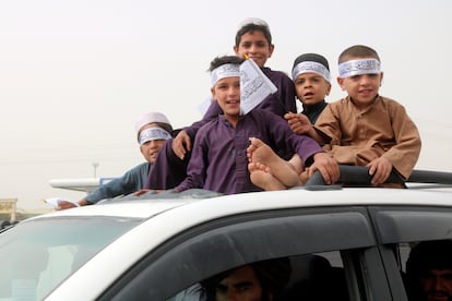 Children hold Taliban flags during a celebration