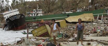 Dos filipinos se abren paso entre los escombros de Tacloban. 